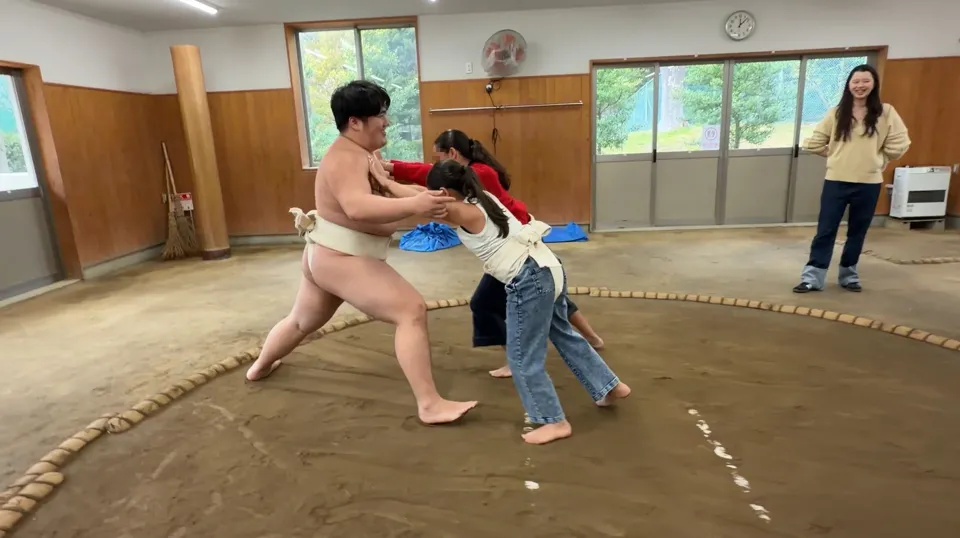A child trying sumo with an instructor